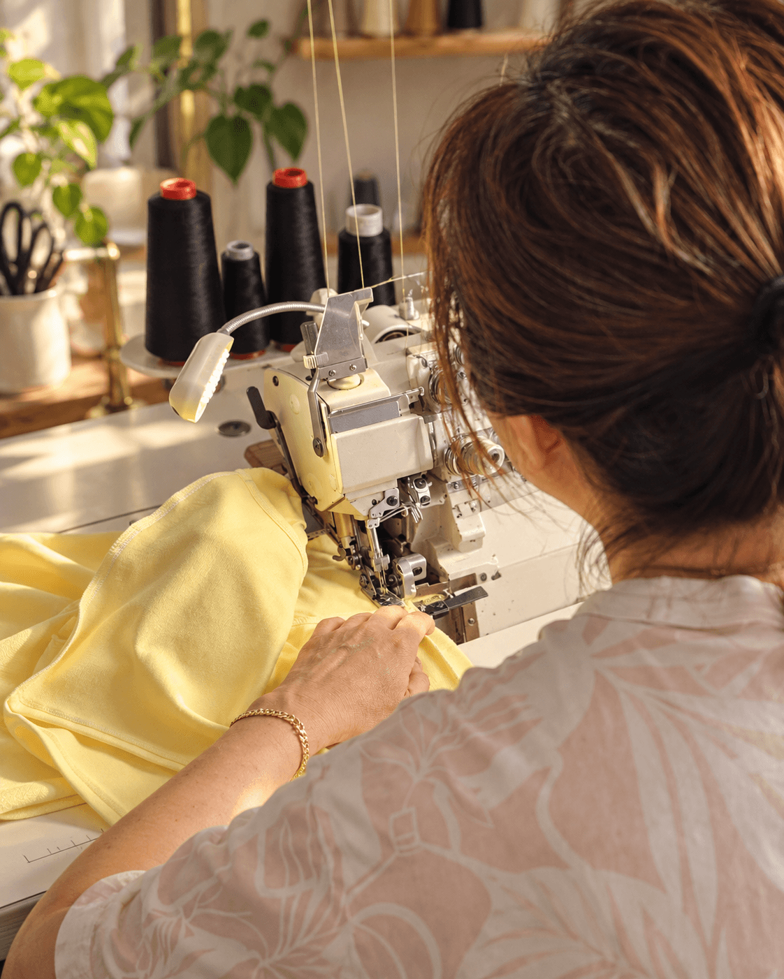 Becky carefully sewing a garment in her studio